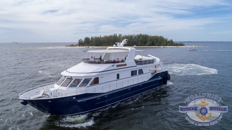 Island Soul Yacht Photos Pics Custom 2009 Flybridge Motoryacht cruising near an island, open water, Worldwide Yacht Sales logo.