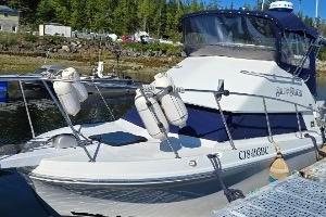1997 Skipjack 262 Flybridge boat docked, featuring a sleek design and blue canopy.