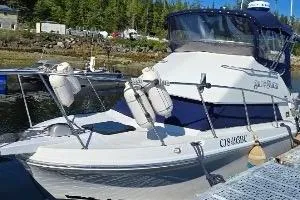 1997 Skipjack 262 Flybridge boat docked, featuring a sleek design and blue canopy.