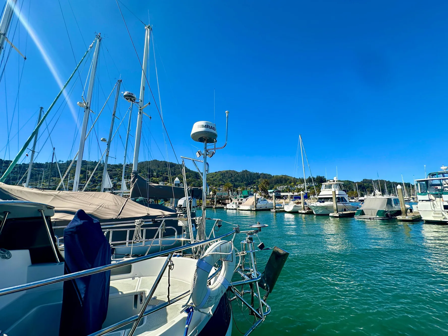 Sailboats docked in a marina under clear blue skies, featuring a 1996 Valiant 39.