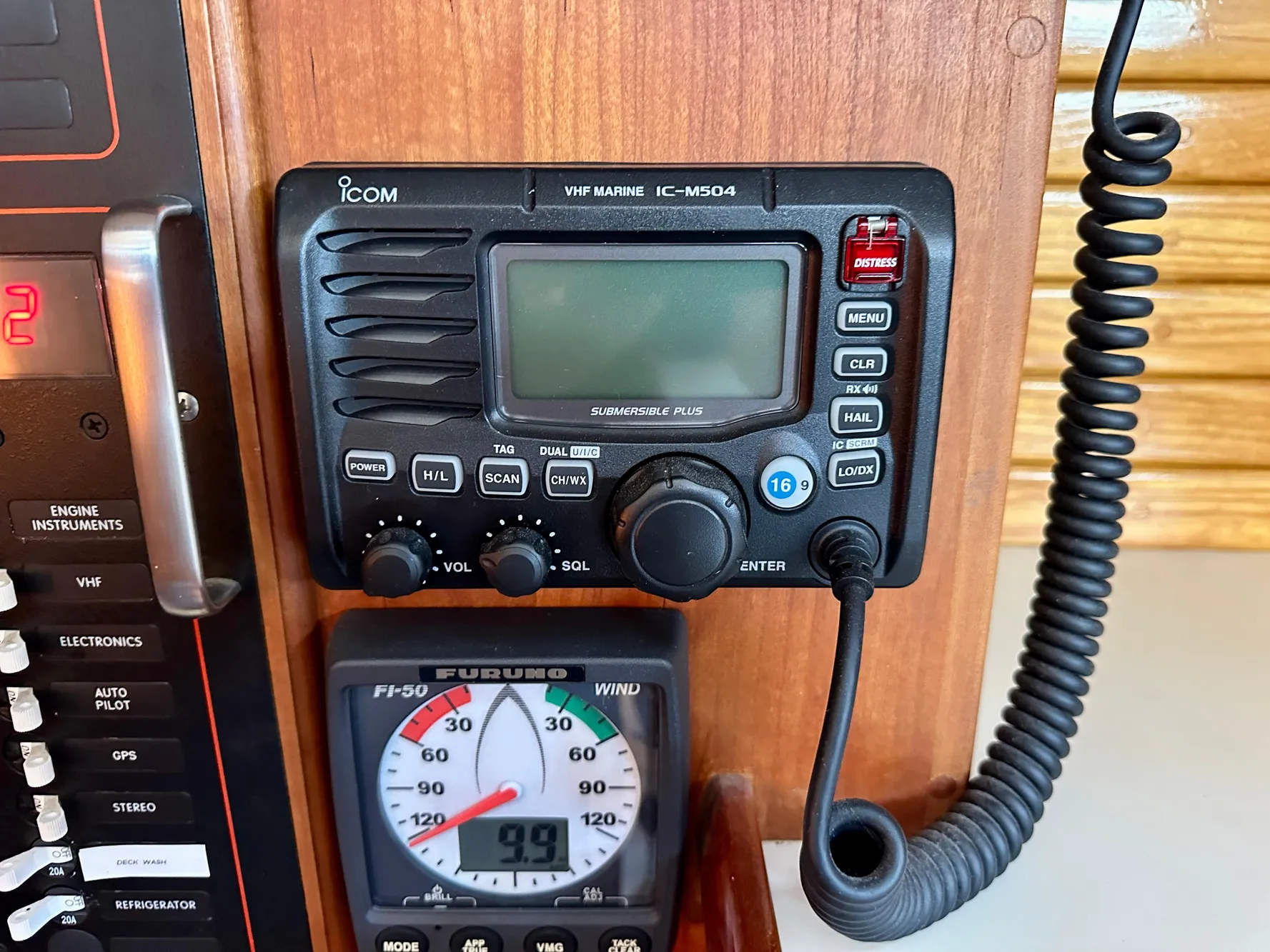 VHF marine radio and wind gauge on a 1996 Valiant 39 sailboat dashboard.