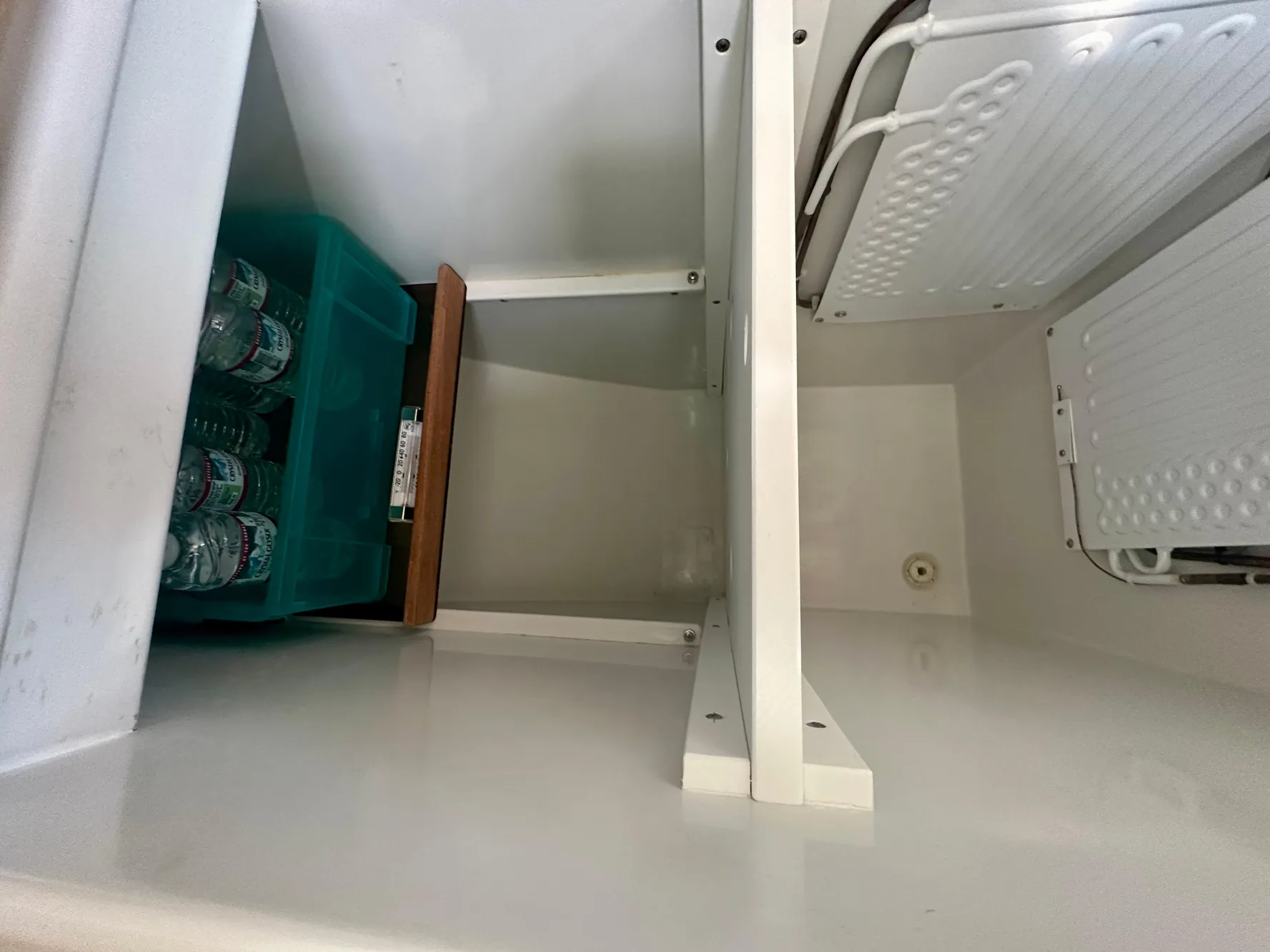 Storage compartment in a 1996 Valiant 39 boat with water bottles.