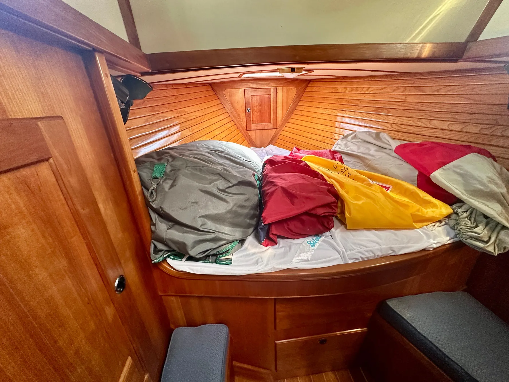 Cozy cabin interior of a 1996 Valiant 39 sailboat with colorful bedding.