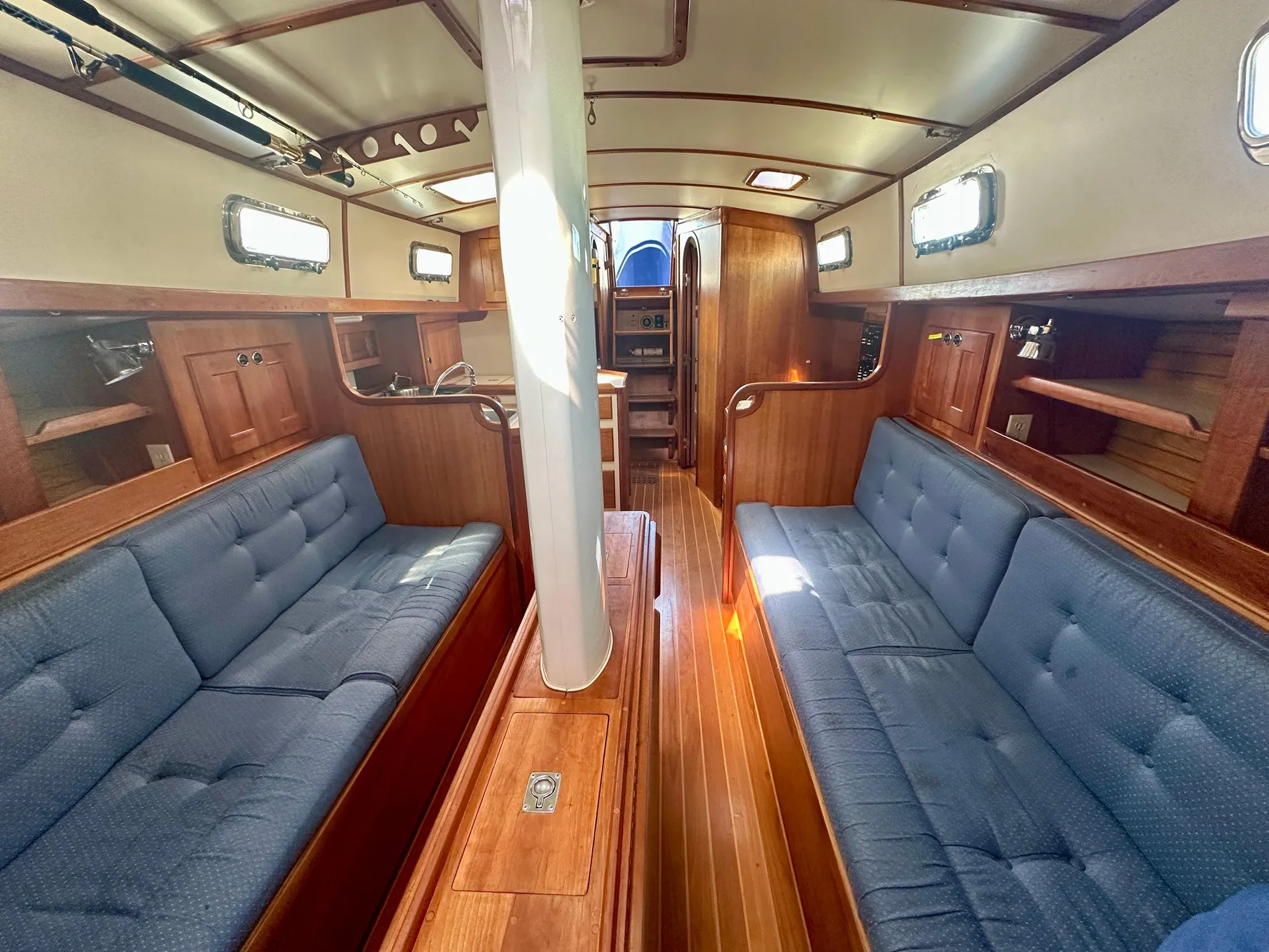 Spacious interior of 1996 Valiant 39 sailboat with wooden finish and blue seating.