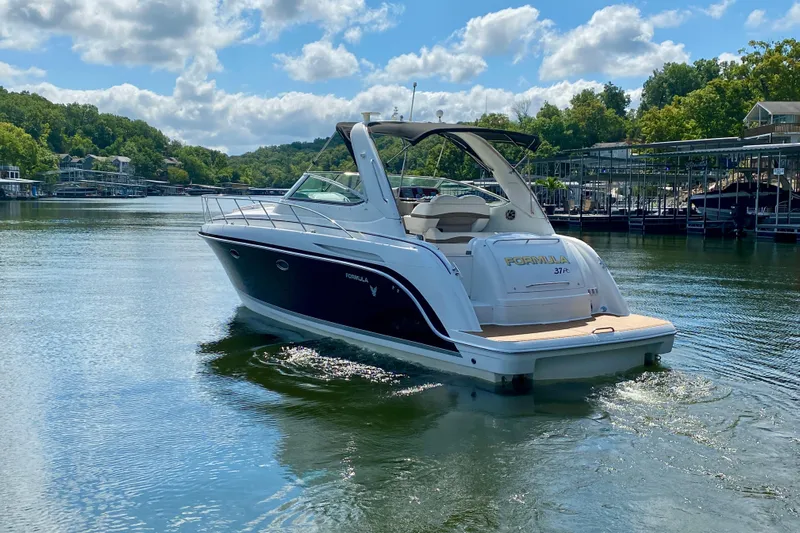  Yacht Photos Pics 2004 Formula 37 PC yacht cruising on a serene lake under a blue sky.