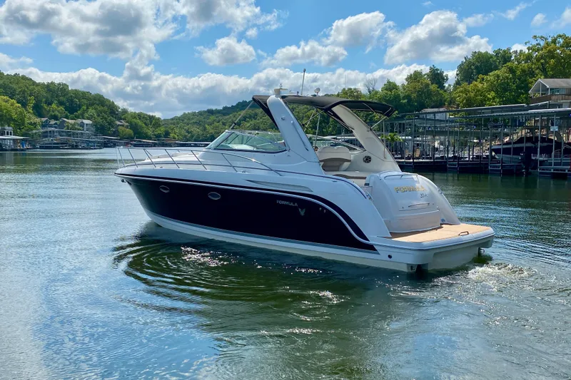  Yacht Photos Pics 2004 Formula 37 PC yacht cruising on a sunny lake with lush green surroundings.