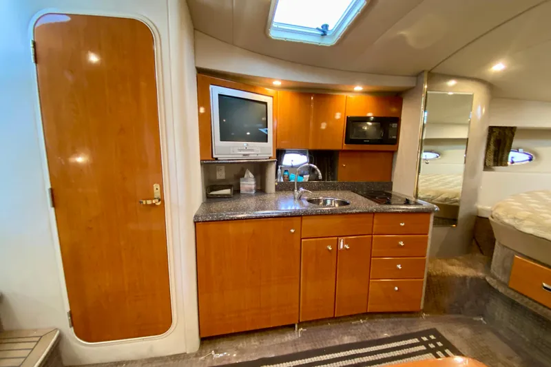  Yacht Photos Pics 2004 Formula 37 PC yacht interior with kitchenette, TV, and cozy sleeping area.