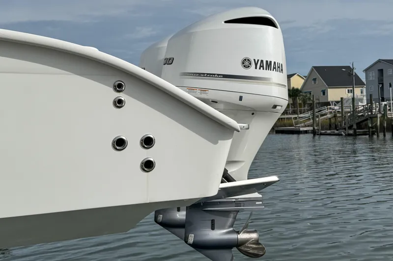  Yacht Photos Pics Cape Horn 31 T boat with Yamaha outboard motor, docked near waterfront homes.