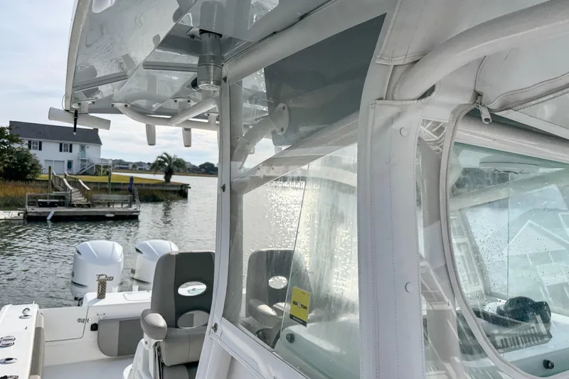  Yacht Photos Pics 2021 Cape Horn 31 T boat with clear enclosure, docked near waterfront homes.