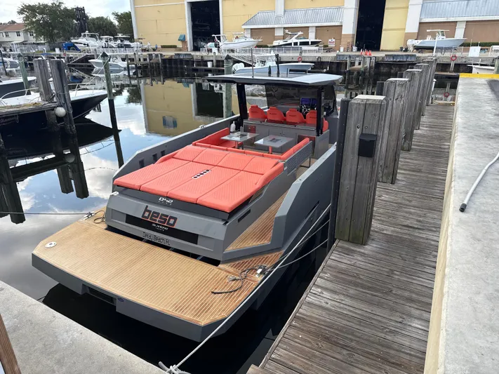  Yacht Photos Pics 2021 De Antonio Yachts D42 docked, featuring sleek design and vibrant red seating.