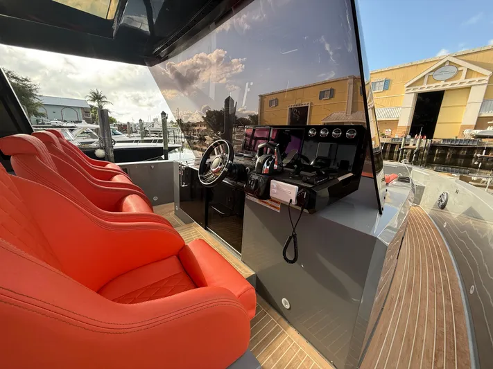  Yacht Photos Pics Red seats and sleek helm of 2021 De Antonio Yachts D42, docked under sunny skies.