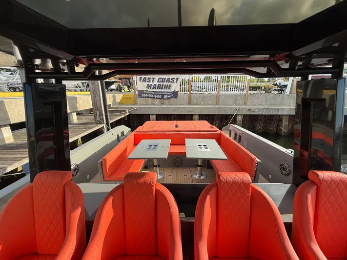  Yacht Photos Pics 2021 De Antonio Yachts D42 with vibrant red seating and dual tables at a marina.