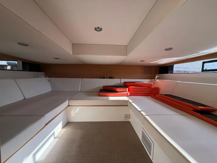 Yacht Photos Pics Interior of 2021 De Antonio Yachts D42 with white seating and red cushions.
