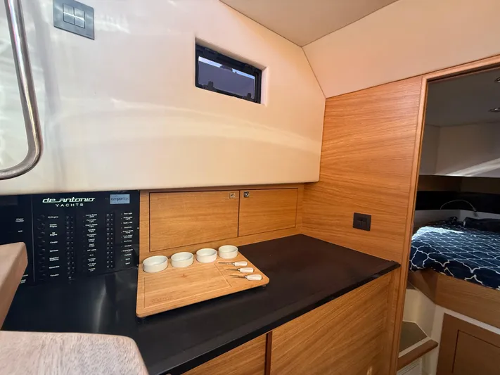  Yacht Photos Pics Interior of 2021 De Antonio Yachts D42, featuring a sleek wooden kitchenette and cozy cabin.
