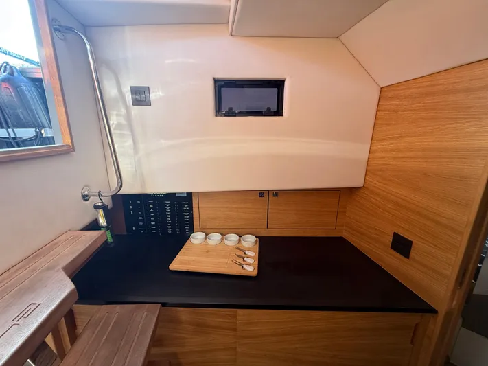  Yacht Photos Pics Interior of 2021 De Antonio Yachts D42, featuring a sleek wooden kitchenette.
