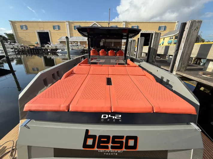  Yacht Photos Pics 2021 De Antonio Yachts D42 with orange seating, docked at a marina.