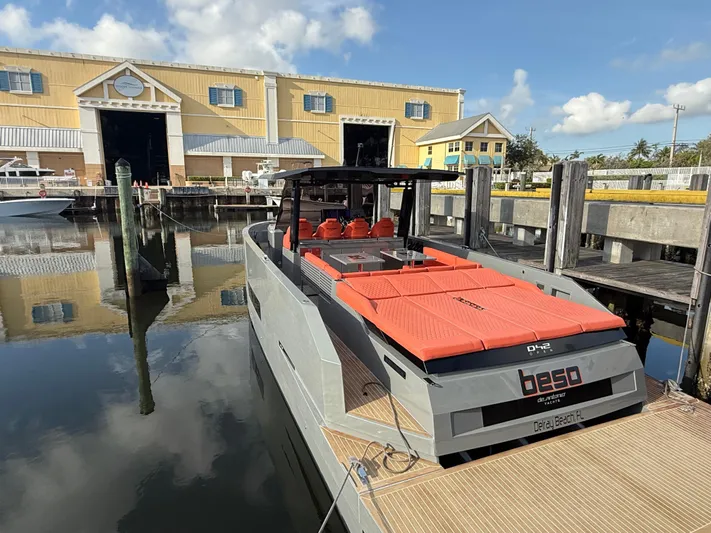  Yacht Photos Pics 2021 De Antonio Yachts D42 docked, featuring sleek design and vibrant orange seating.