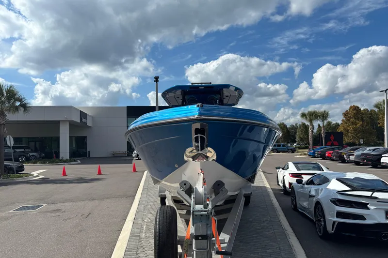  Yacht Photos Pics 2024 GSX 36 boat on trailer at dealership, with sports cars and cloudy sky.