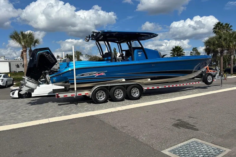  Yacht Photos Pics 2024 GSX 36 boat on trailer, blue exterior, parked outdoors under cloudy sky.