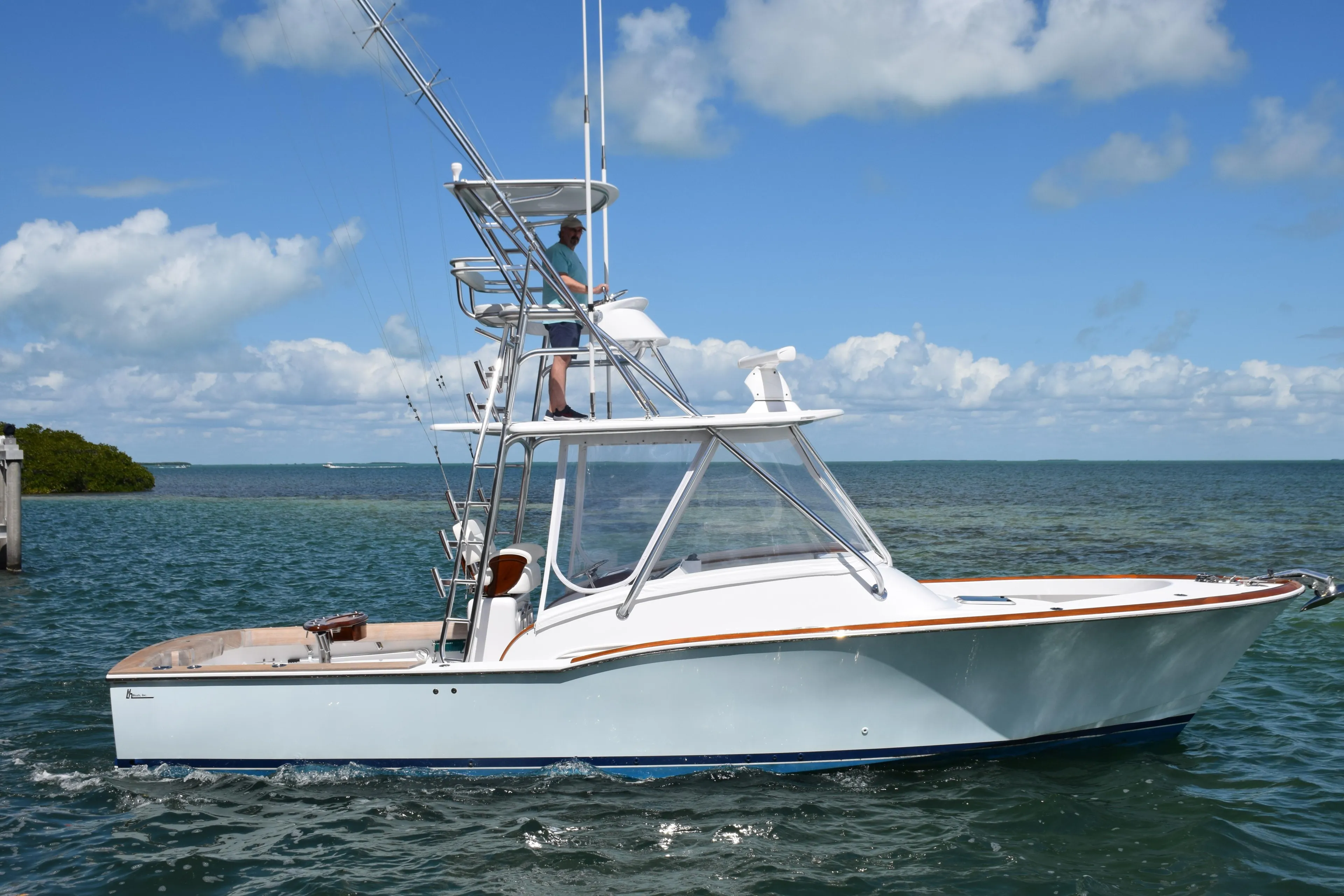 2024 L&H Walk-Around Sportfish boat on the water under a blue sky.