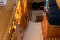 Interior of 1998 ACM Heritage 26 boat with wooden cabinetry and seating.