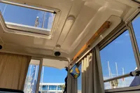 Interior view of 1998 ACM Heritage 26 boat with skylight and curtains.