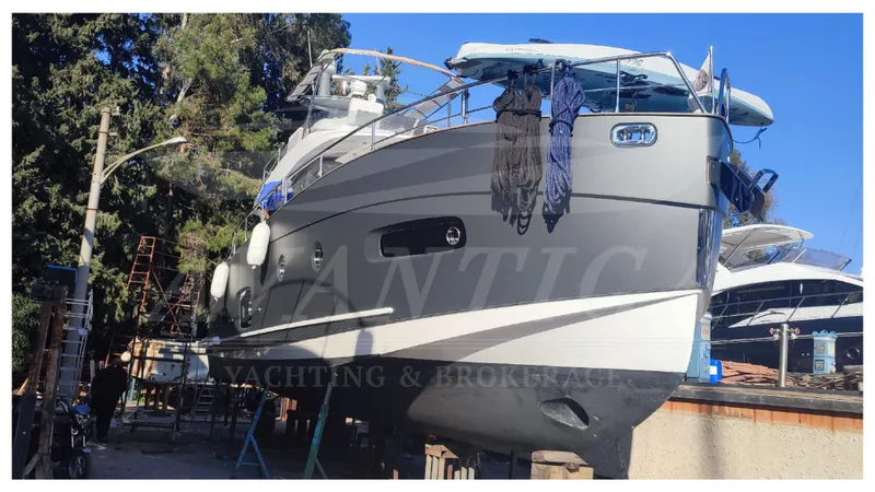  Yacht Photos Pics 2015 Azimut Magellano 53 yacht on dry dock, surrounded by trees and equipment.