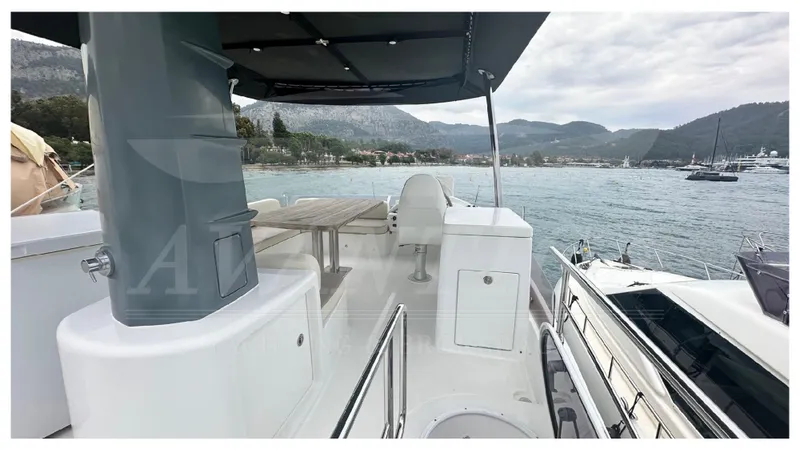  Yacht Photos Pics 2015 Azimut Magellano 53 yacht deck with seating, table, and scenic waterfront view.