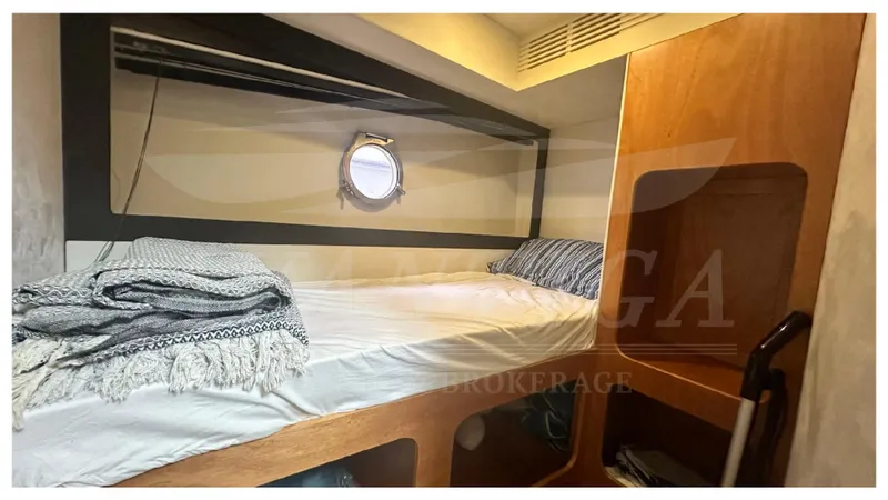  Yacht Photos Pics Cozy cabin interior of 2015 Azimut Magellano 53 yacht with bed and porthole.