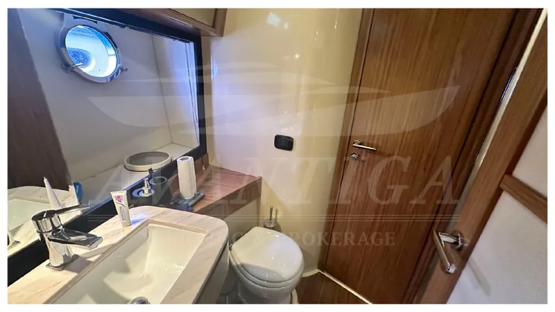  Yacht Photos Pics Bathroom interior of 2015 Azimut Magellano 53 yacht, featuring sink, toilet, and porthole.