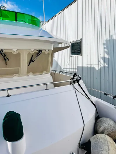 Journey Yacht Photos Pics Bracewell Latitude 47 yacht, 2001 model, docked with fenders, white exterior, green accents.