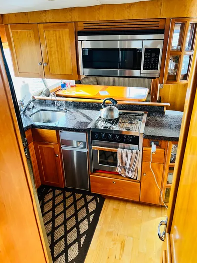 Journey Yacht Photos Pics Kitchen area of 2001 Bracewell Latitude 47 yacht with modern appliances and wooden cabinetry.