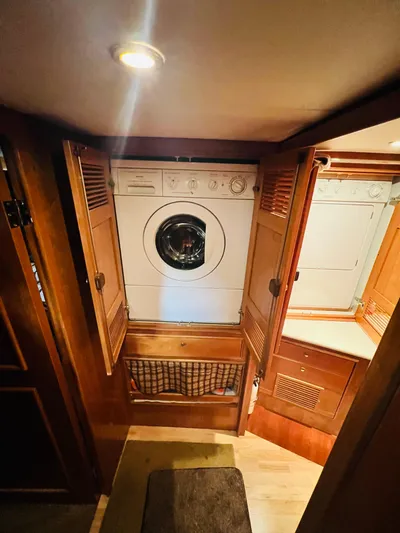 Journey Yacht Photos Pics Laundry area inside 2001 Bracewell Latitude 47 yacht, featuring a built-in washer and dryer.