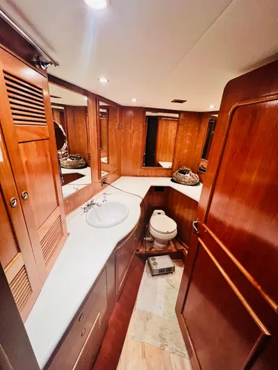 Journey Yacht Photos Pics Luxurious yacht bathroom with wooden cabinetry, sink, and toilet, Bracewell Latitude 47, 2001 model.