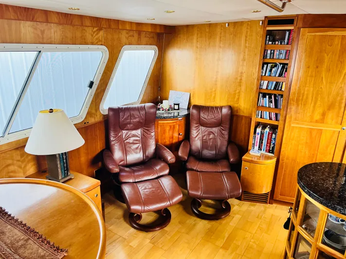 Journey Yacht Photos Pics Luxurious yacht interior with leather chairs, wooden paneling, and bookshelf. Bracewell Latitude 47, 2001 model.