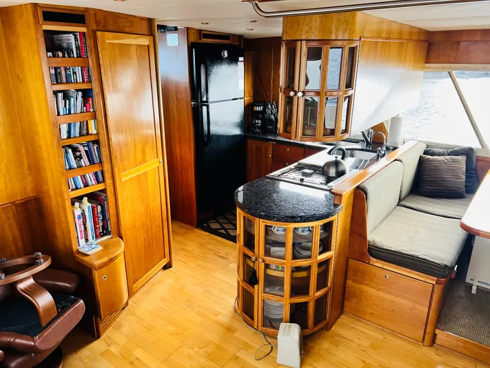 Journey Yacht Photos Pics Luxurious Bracewell yacht interior with wooden cabinetry, kitchen, seating, and bookshelf, model Latitude 47, 2001.