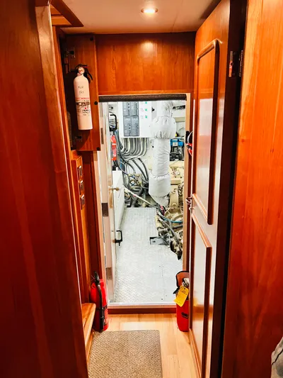 Journey Yacht Photos Pics Engine room entrance of 2001 Bracewell Latitude 47 yacht, featuring wooden interior and safety equipment.