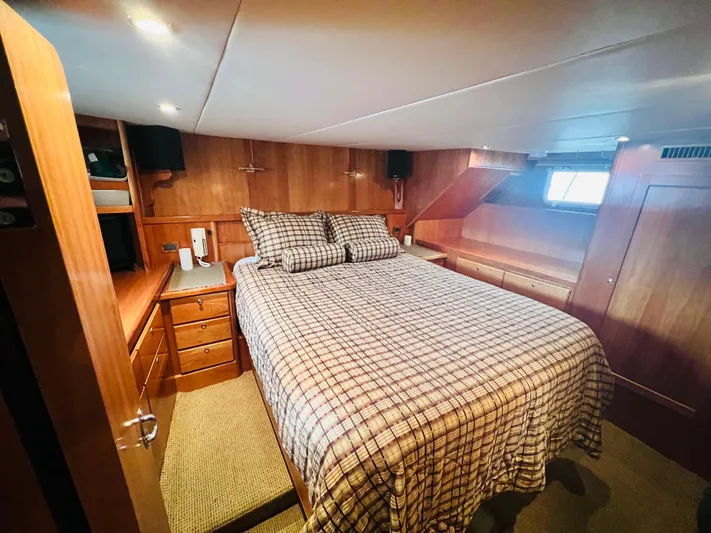 Journey Yacht Photos Pics Luxurious cabin interior of 2001 Bracewell Latitude 47 yacht, featuring a cozy bed and wooden furnishings.