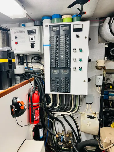 Journey Yacht Photos Pics Electrical panel in a 2001 Bracewell Latitude 47 yacht engine room, featuring wiring and safety equipment.