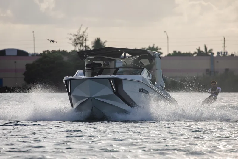  Yacht Photos Pics 2025 Nautique Super Air Nautique G25 Paragon towing a wakeboarder on a sunny day.