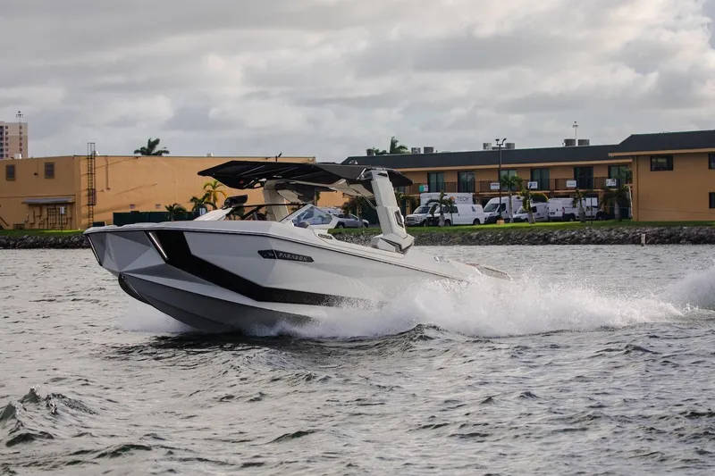  Yacht Photos Pics 2025 Nautique Super Air Nautique G25 Paragon cruising on water near buildings.