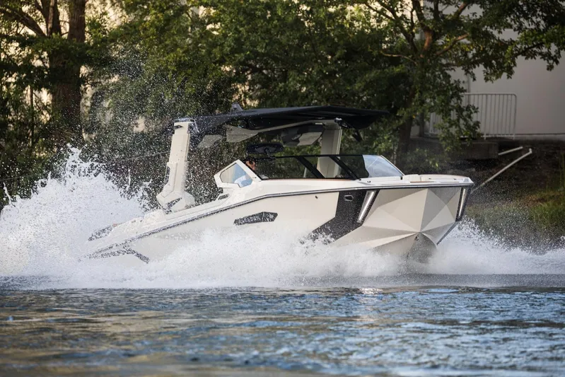  Yacht Photos Pics 2025 Nautique Super Air Nautique G25 Paragon cruising on water, creating a splash.