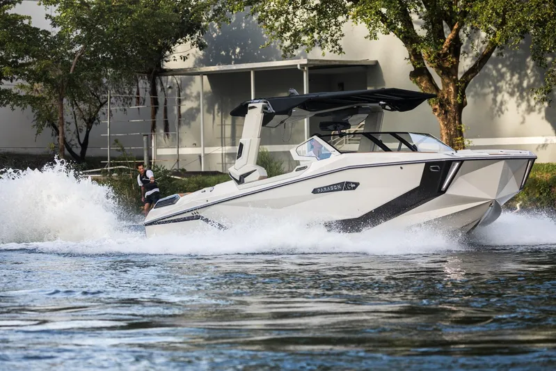  Yacht Photos Pics 2025 Nautique Super Air Nautique G25 Paragon cruising on water with wakeboarder.