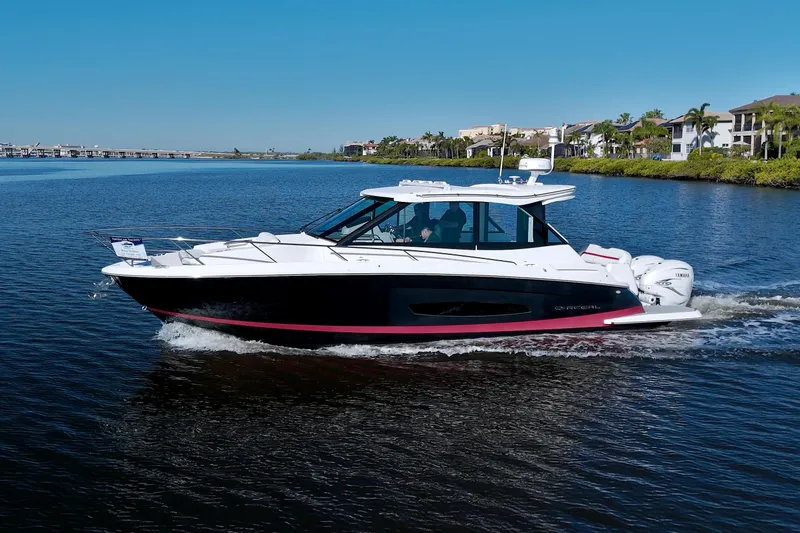 Elena Trinidad Yacht Photos Pics 2021 Regal 36 XO boat cruising on a calm lake under a clear blue sky.