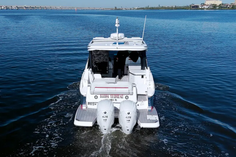 Elena Trinidad Yacht Photos Pics 2021 Regal 36 XO boat cruising on calm water, rear view.