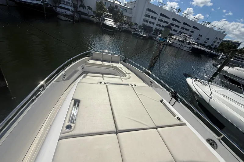 Chicken Money Yacht Photos Pics 2023 Azimut Verve 47 yacht with spacious sunbathing deck, docked in a marina.