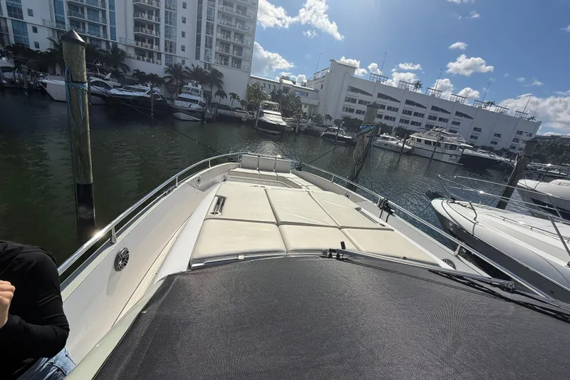 Chicken Money Yacht Photos Pics 2023 Azimut Verve 47 yacht docked at marina with luxury seating and cityscape backdrop.