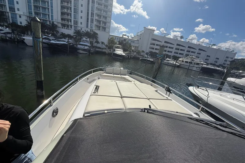 Chicken Money Yacht Photos Pics 2023 Azimut Verve 47 yacht docked at marina with modern buildings in background.