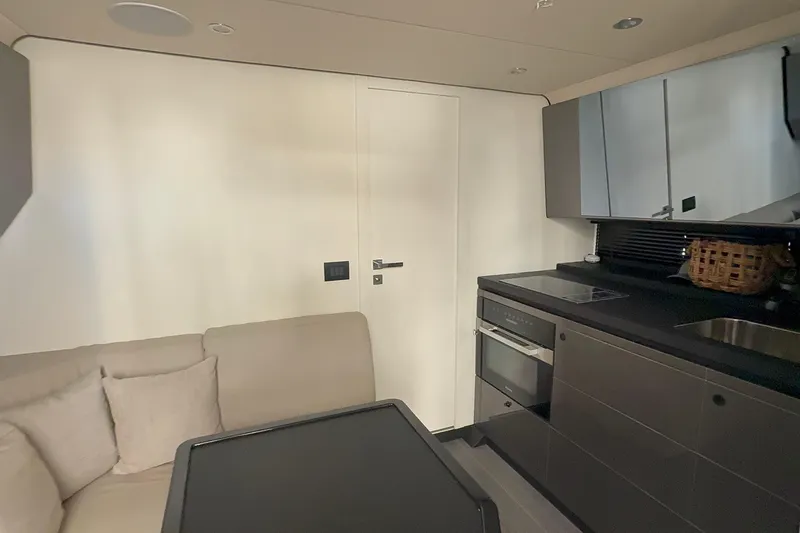 Chicken Money Yacht Photos Pics Modern interior of 2023 Azimut Verve 47 yacht with sleek kitchen and cozy seating area.