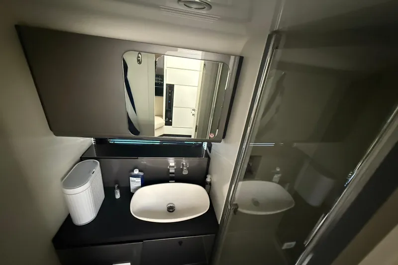 Chicken Money Yacht Photos Pics Modern bathroom interior of 2023 Azimut Verve 47 yacht, featuring sleek sink and mirror.